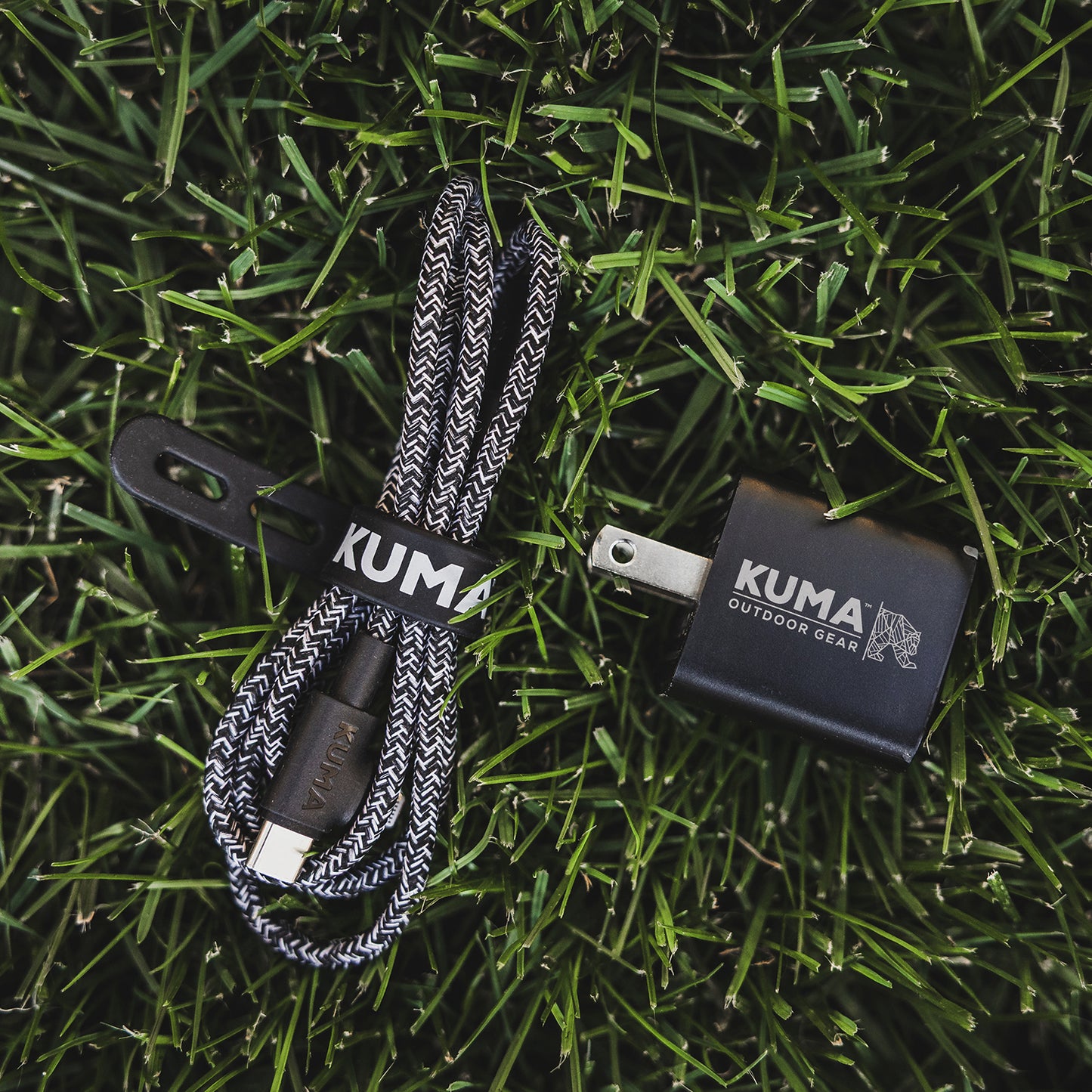 Kuma outdoor gear charging cable and adapter on grass