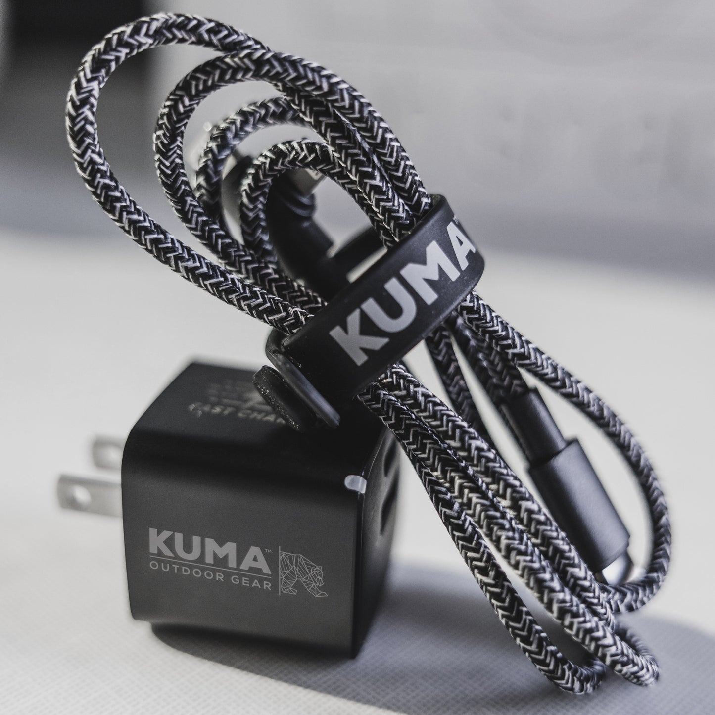 Kuma outdoor gear charging cable and adapter on a neutral background