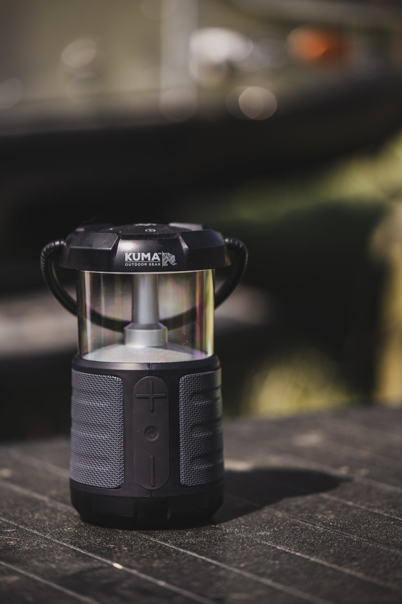 Black lantern with 'Kuma' branding on a dark surface