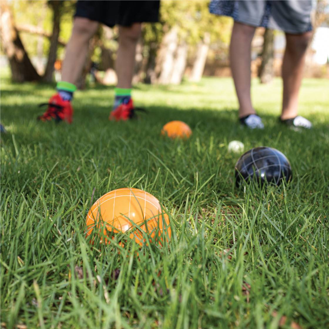Kuma Bocce Ball Set in action on a grassy field during a family picnic.