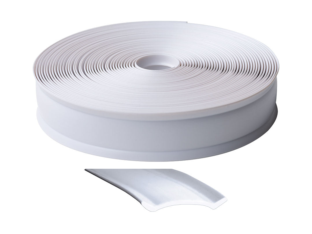 Roll of white trim molding with a piece peeled off on a white background