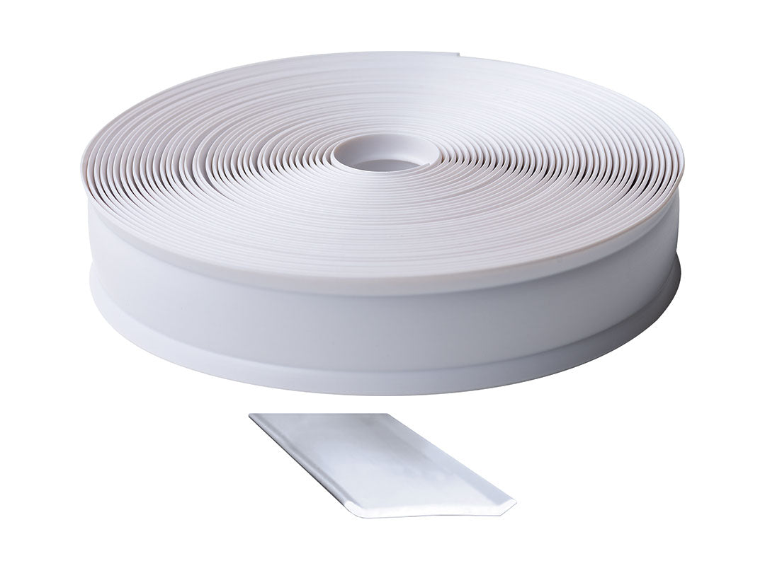 Roll of white trim molding insert with a small piece cut off on a white background