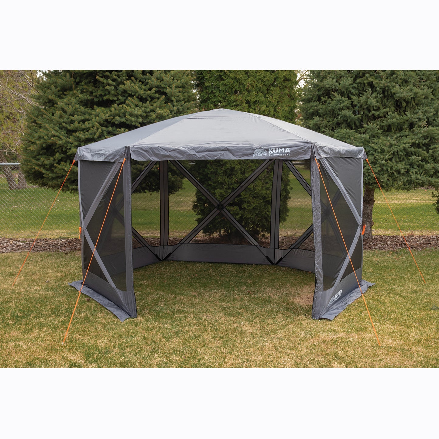 Outdoor canopy tent with screen walls on a grassy area with trees in the background