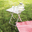 Folding table with drinks on a grassy background