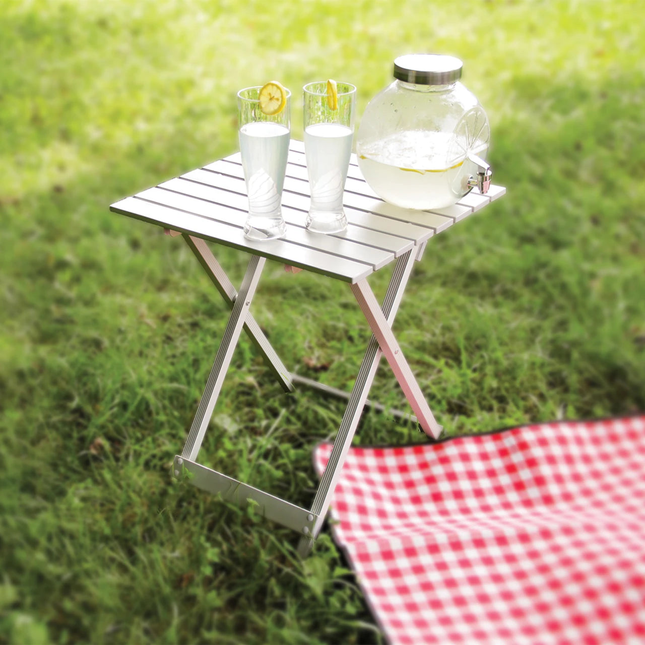 Folding table with drinks on a grassy background