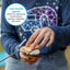 Person holding a s'more with skewer, wearing a blue shirt with a geometric design.