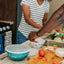 Two people preparing food in a kitchen with a focus on a teal container labeled 'Camperite'.