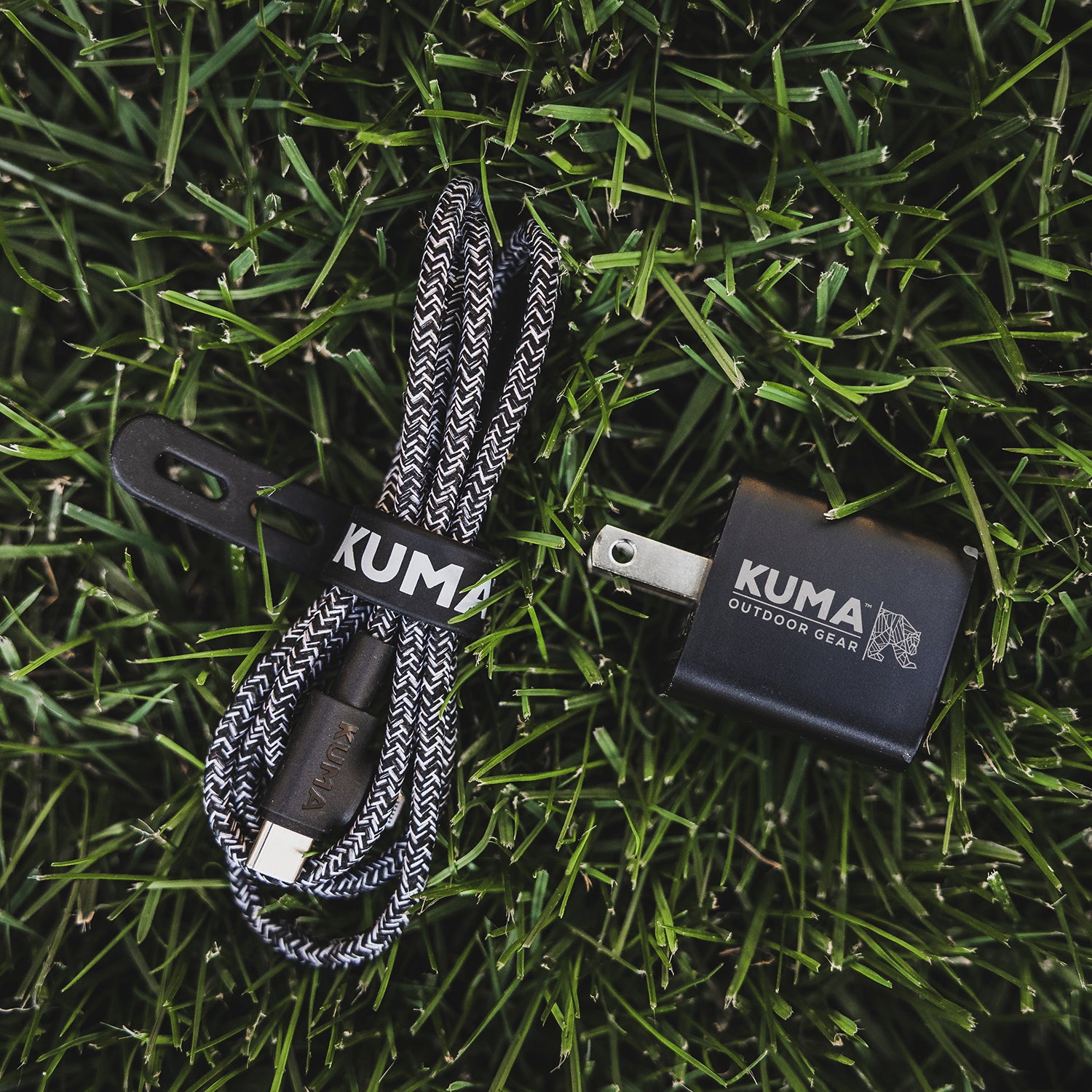 Kuma outdoor gear charging cable and adapter on grass