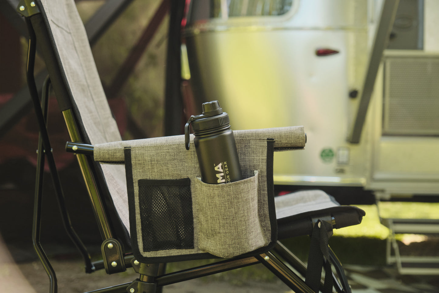 Chair with a pocket holding a water bottle in front of a vintage van.