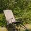 Foldable rocking chair on grass with greenery in the background