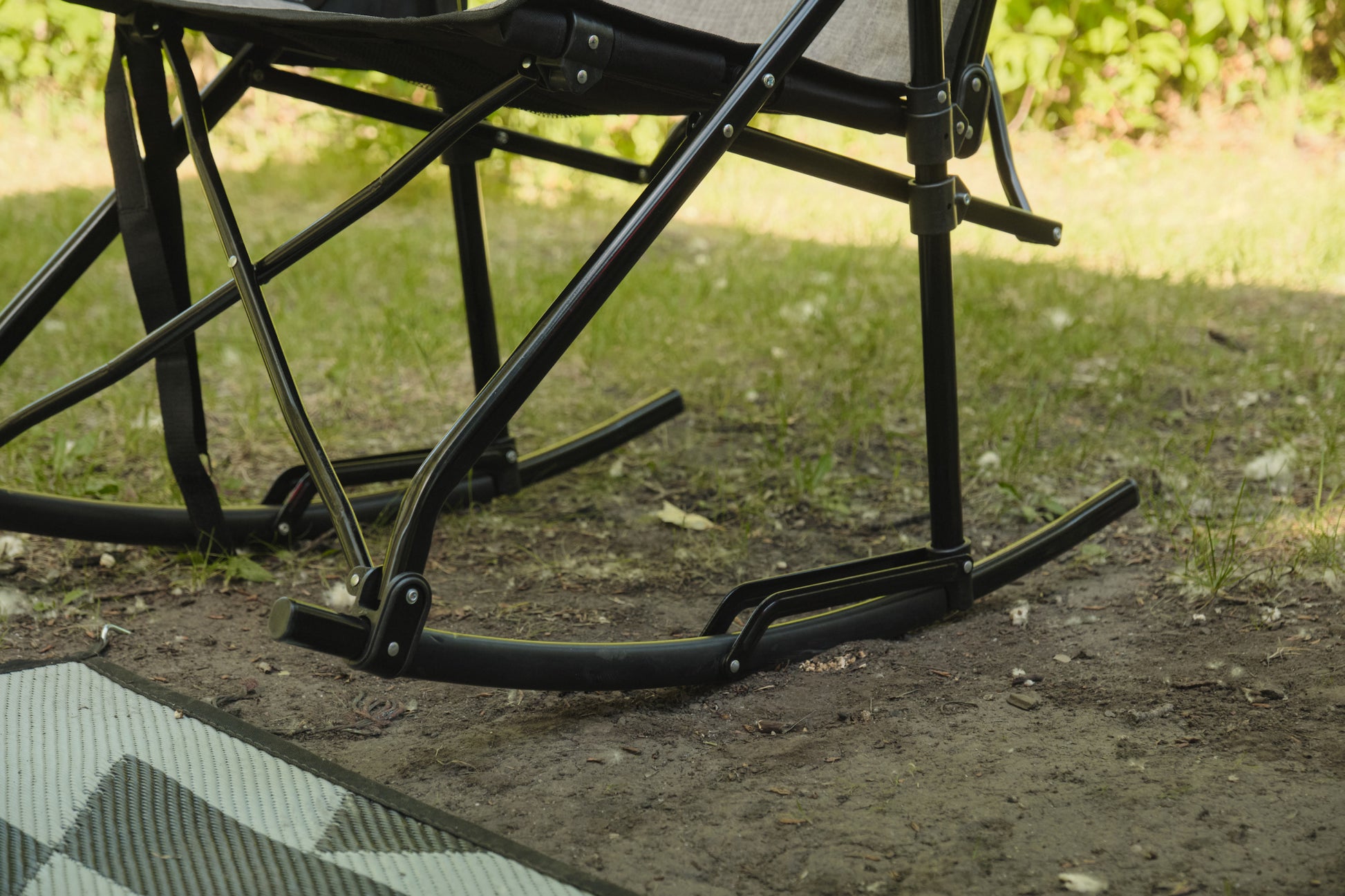 Close-up of a black metal chair with a blurred natural background