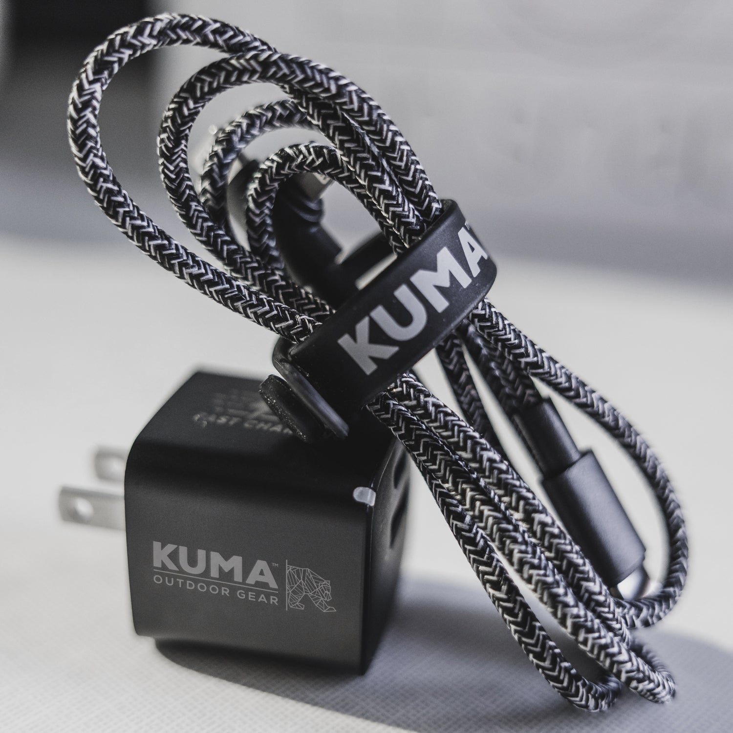 Kuma outdoor gear charging cable and adapter on a neutral background