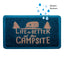 A rectangular doormat with a dark teal textured surface and a copper-toned graphic that reads “Life is Better at the Campsite,” featuring a small camper trailer and trees. Blue raindrop graphics with the text “Weather Resistant” appear above the mat on a white background.