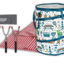 A camping picnic set displayed on a white background, including a cylindrical storage bag with a blue and white woodland pattern, a red-and-white gingham blanket, a gray drawstring pouch labeled CANCO, four hand tools with black handles, and a stack of bowls in white and turquoise.
