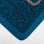 A close-up of a dark teal textured mat with a thick solid border and a small tan accent along one edge, shown on a white background.