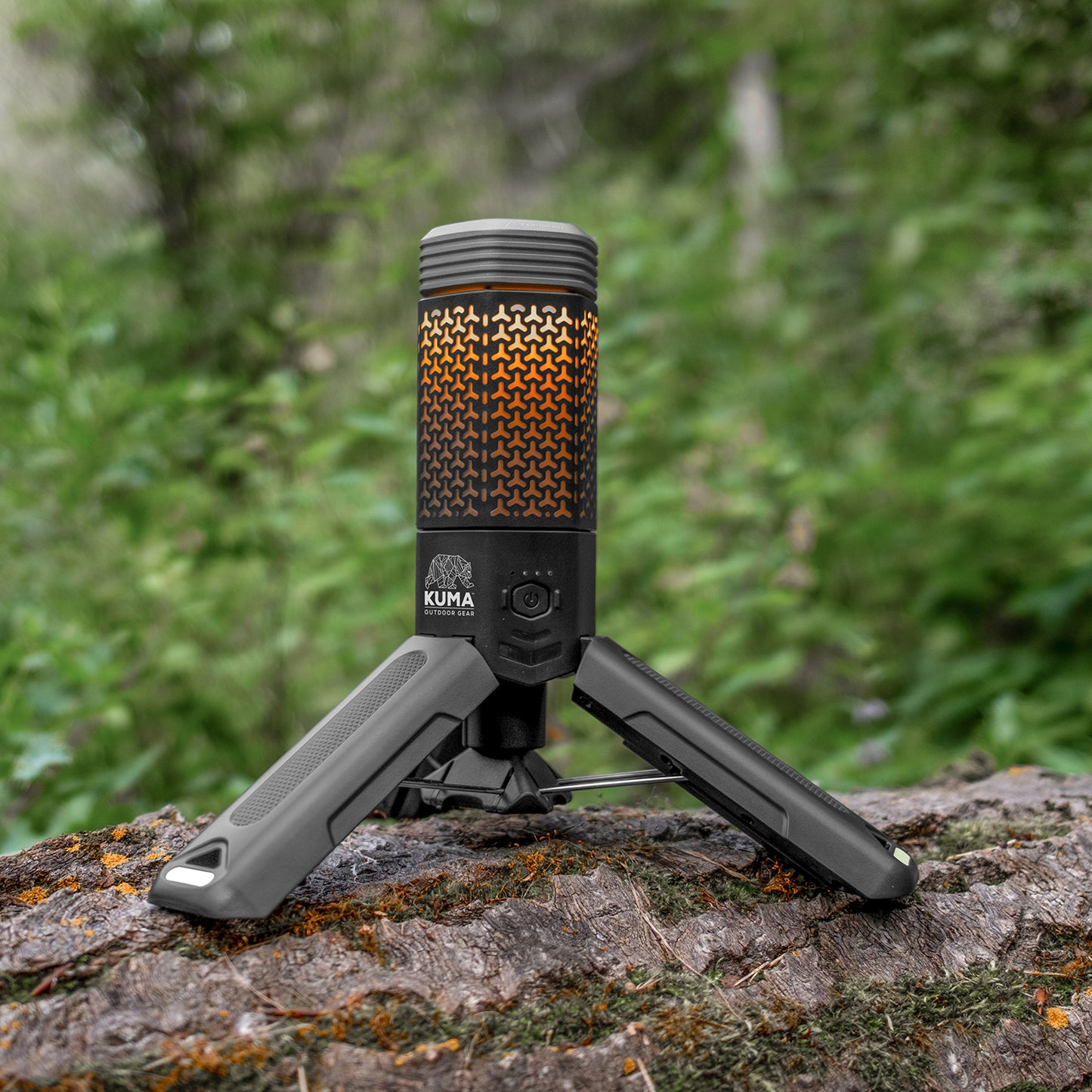 Portable camping stove on a log with a forest background
