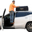Using a door latch step to access roof rack at campsite
