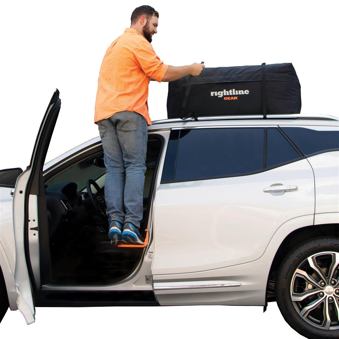 Using a door latch step to access roof rack at campsite
