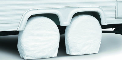 A pair of white RV wheel covers placed on the front of a vehicle.