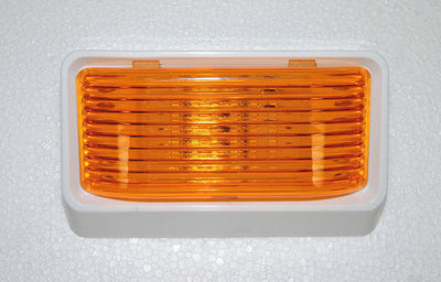 Optronics RV porch light with amber lens and white housing